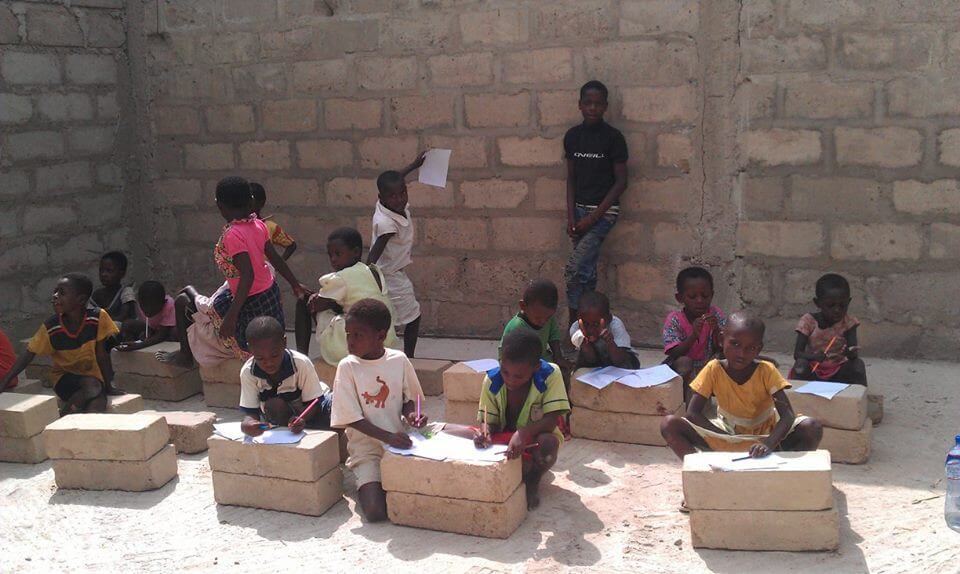 humanilog Transport Sachspenden go for ghana Kinder schreiben auf Steinbloecken