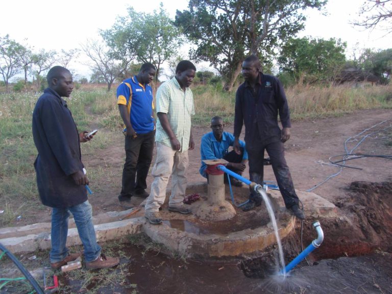 humanilog Transport Sachspenden Naume Kinderstiftung Uganda Maenner an Brunnen